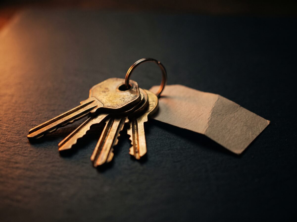 A set of brass house keys resting on a dark counter